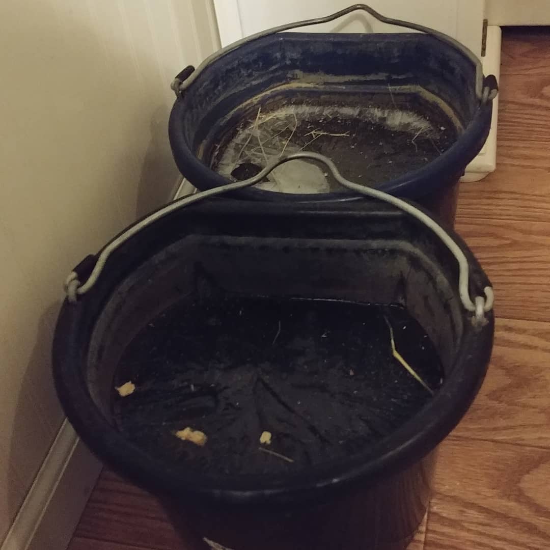 two black rubber buckets indoors